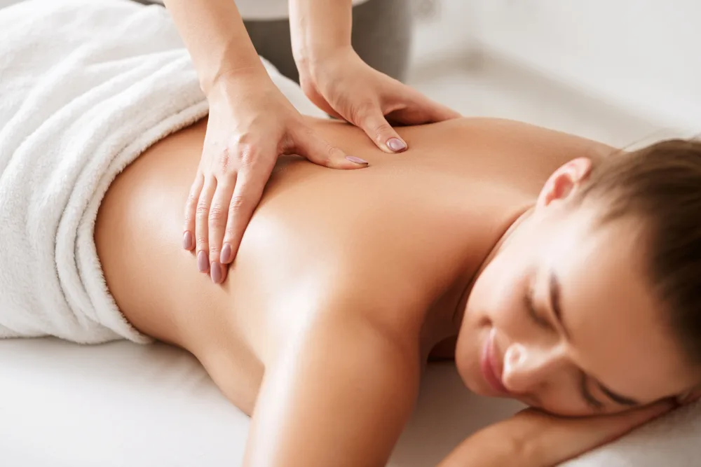 Gentle hands-on back massage with soft white towels